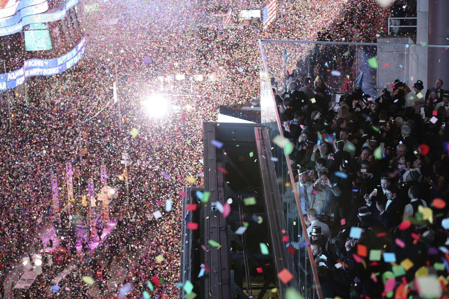 Revelers celebrate as confetti flies over New York's Times Square after the clock strikes midnight during the New Year's Eve celebration as seen from the New York Marriott Marquis hotel.