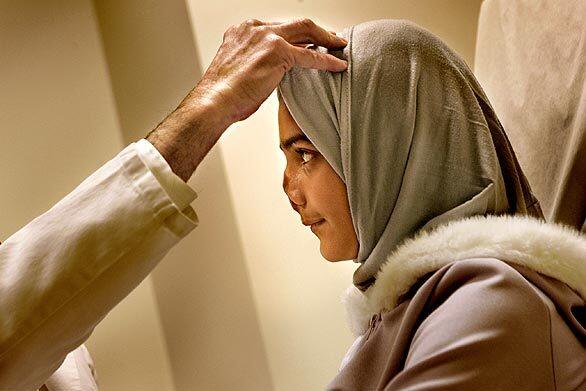 Marwa peers into the eyes of Dr. Tim Miller at UCLA Medical Center, where she will have four surgeries, all free, to reconstruct her nose. The blast that injured her razed her house on Baghdad's outskirts and killed her mother.