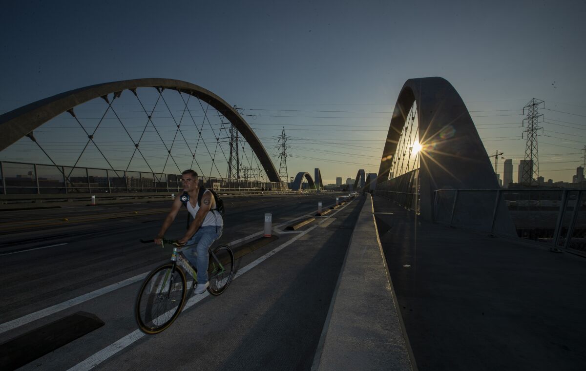 A cyclist rides in the bike lane crosses the new 6th Street Bridge.