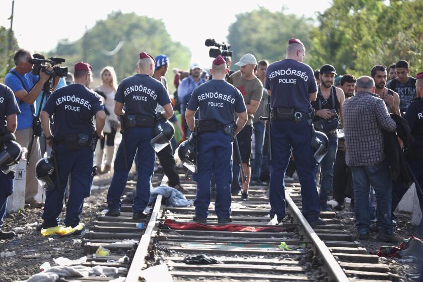 Hungarian police block the track at the Hungarian-Serbian border on Monday, preventing migrants from crossing.