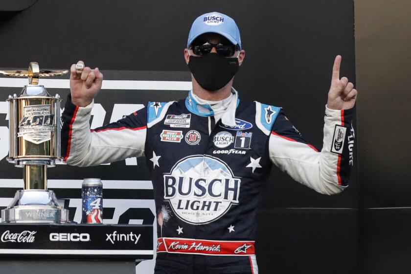 Race driver Kevin Harvick celebrates after winning the NASCAR Cup Series auto race at Indianapolis Motor Speedway.
