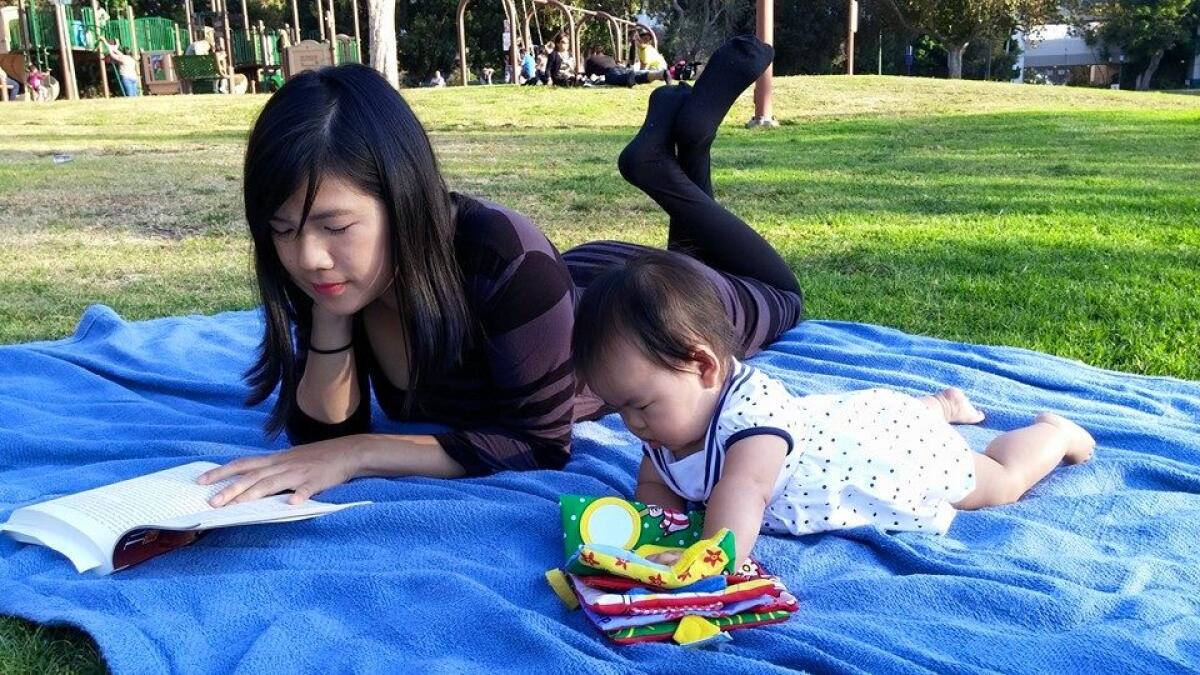 Jessica Ko reads to her then-six-month-old daughter outside the Memorial Branch Library in Los Angeles in 2015.