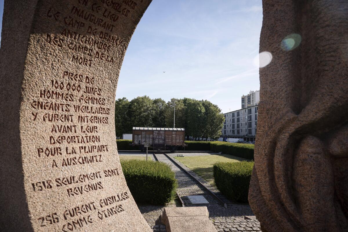 A memorial is pictured near a train car symbolizing the Drancy camp, at the Shoah memorial Tuesday, July 12, 2022 in Drancy, outside Paris. The Paris mayor and head of the French Holocaust Memorial will mark the 80th anniversary of the round-up of the Vel d'Hiv, the biggest Nazi roundup of Jews in France, visiting the site used as an internment camp during World War II for tens of thousands of people who were then sent on to Auschwitz and other death camps. (AP Photo/Thomas Padilla)