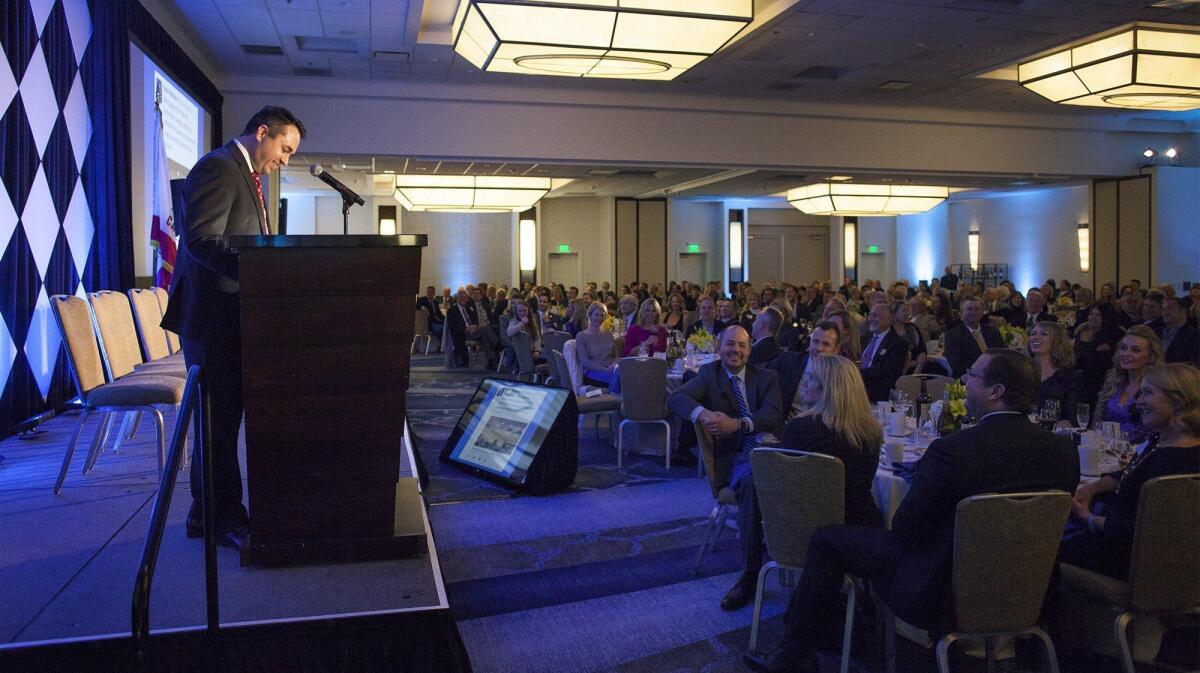 Newport Beach Mayor Kevin Muldoon shares a laugh with his guests as he gives the state of the city address during the 36th annual Mayor’s Dinner at the Newport Beach Marriott Hotel and Spa on Friday.