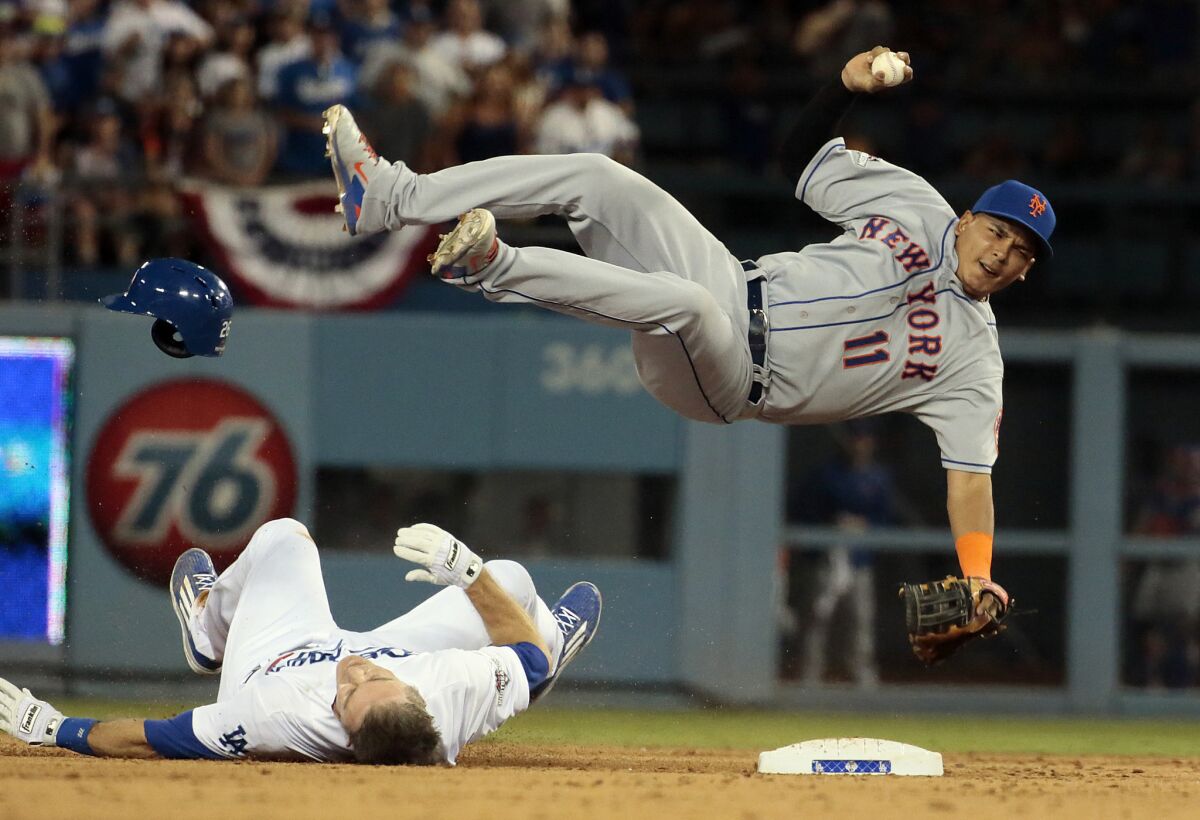 Mets shortstop Ruben Tejada is sent flying by the Dodgers' Chase Utley during a playoff game in October.
