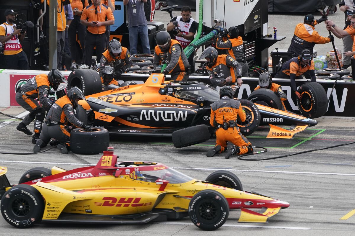 Pato O'Ward pits as Romain Grosjean drives past on pit row during the IndyCar auto race at Texas Motor Speedway.