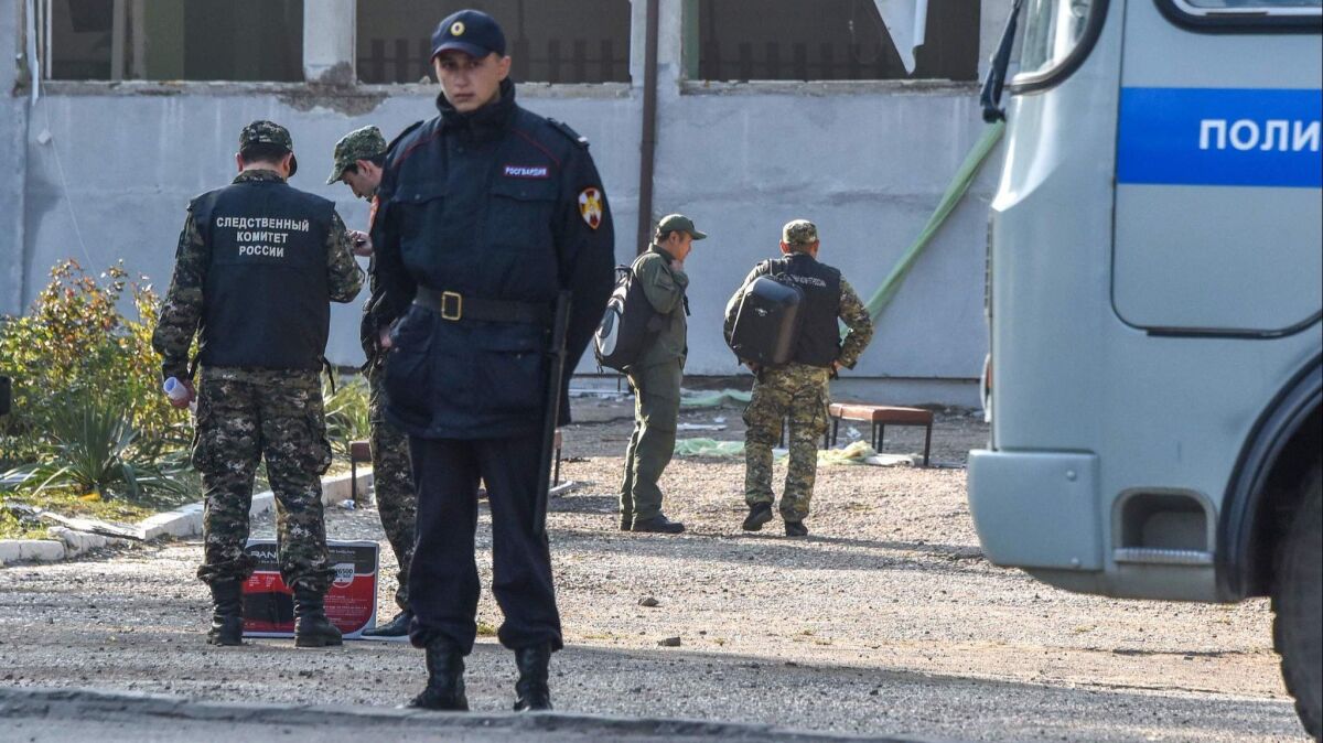 Members of Russia's Investigative Committee work at a college in Kerch, Crimea, on Oct. 18 after a student opened fire.