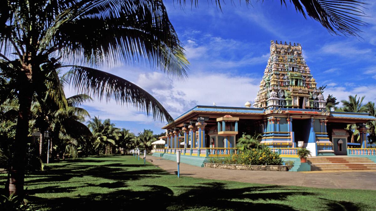 Sri Siva Subramaniya Swami Temple, framed by palm trees and grass in Nadi Fiji. Fiji Airways is offering a $948 round-trip fare.