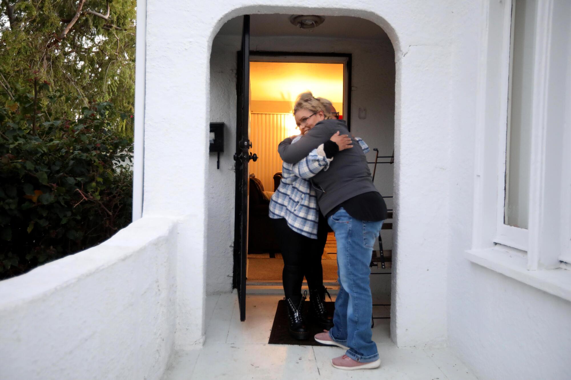  Two women hug outside a home in El Sereno.