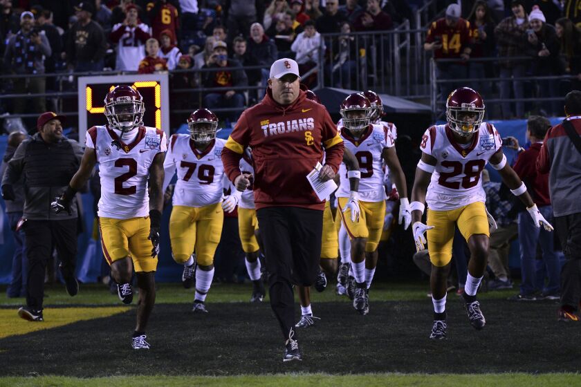 Southern California head coach Clay Helton, center, leads his players onto the field before the Holiday Bowl NCAA college football game against Iowa Friday, Dec. 27, 2019, in San Diego. (AP Photo/Orlando Ramirez)