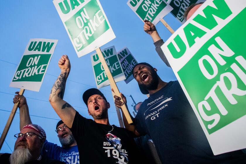General Motors employees Bobby Caughel, left, and Flint resident James Crump, shout out as they protest with other GM employees, United Auto Workers members and labor supporters outside of the Flint Assembly Plant on Monday, Sept. 16, 2019 in Flint, Mich. Thousands of members of the United Auto Workers walked off General Motors factory floors or set up picket lines early Monday as contract talks with the company deteriorated into a strike. (Jake May/The Flint Journal via AP)