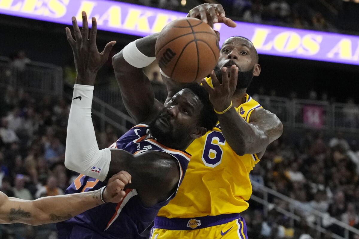 Phoenix Suns center Deandre Ayton and Lakers forward LeBron James battle for the ball.