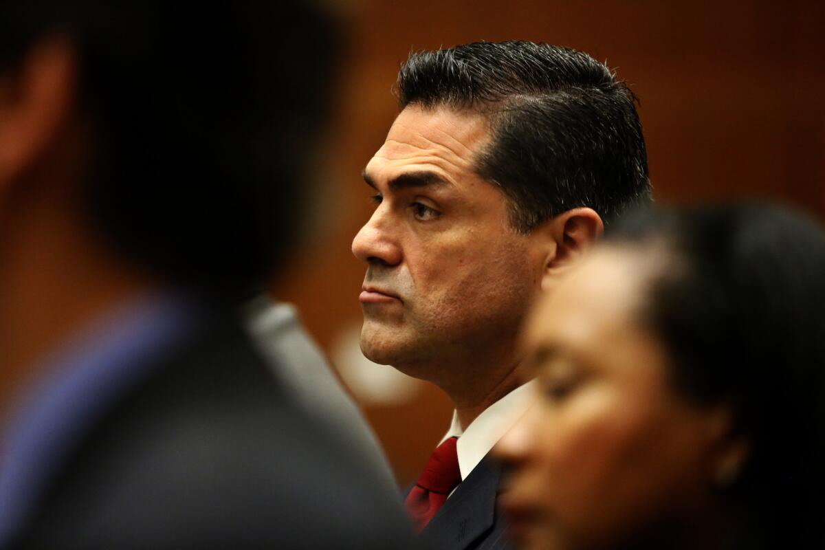 Los Angeles County Assessor John Noguez continues to receive his salary even though he has been charged with illegally lowering the property tax bills for clients of tax consultant Ramin Salari.