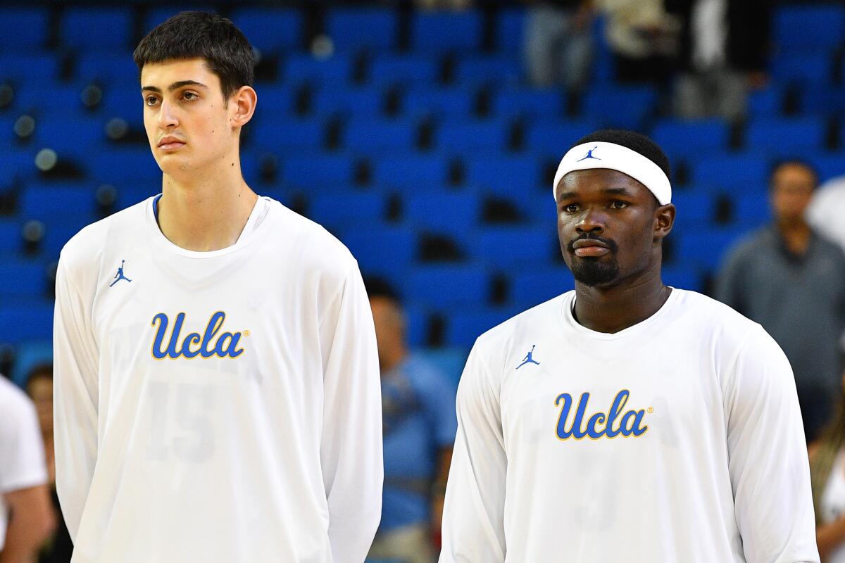 At 7 feet 3, UCLA center Aday Mara, left, towers over teammate Adem Bona.