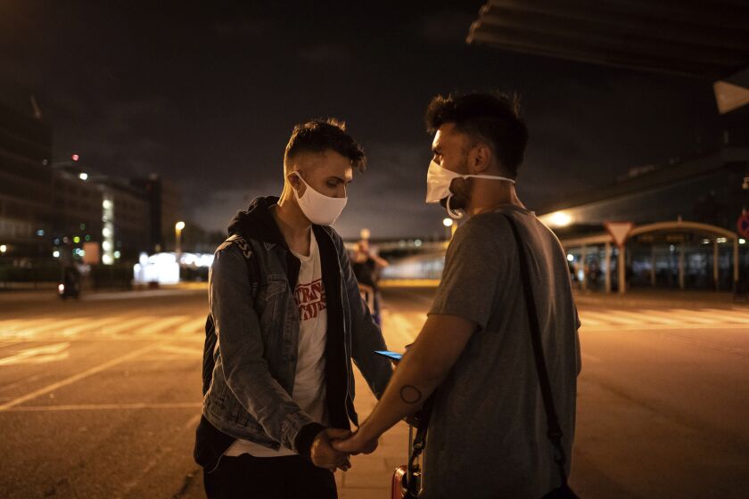 Piotr Grabarczyk and his boyfriend Kamil Pawlik, right, from Poland, wait for a taxi outside the airport after Grabarczyk arrived in Barcelona, Spain, early Wednesday, July 29, 2020. Like them, many LGBT people are choosing to leave Poland amid rising homophobia promoted by President Andrzej Duda and other right-wing populist politicians in power. (AP Photo/Felipe Dana)