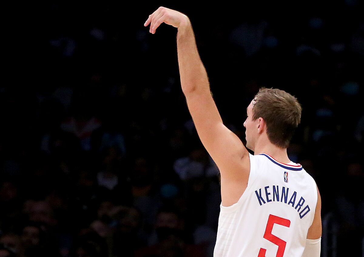 Clippers guard Luke Kennard holds his shooting hand aloft as he watches the arc of a three-pointer.
