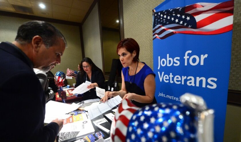 An employee from the Los Angeles County Metropolitan Transportation Authority explains and offers some forms to a Marine veteran at the annual "Honor a Hero - Hire a Vet" job fair in Van Nuys last month.