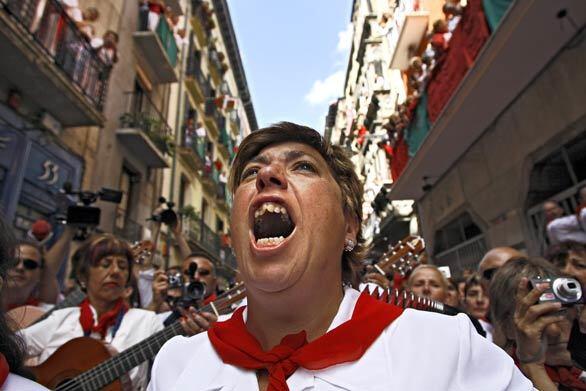 Revelers sing to St. Fermin while participating in a procession in Pamplona in northern Spain during the annual running of the bulls. The festival of Los San Fermines, held since 1591, attracts tens of thousands of foreign visitors each year for nine days of revelry, morning bull runs and afternoon bullfights.