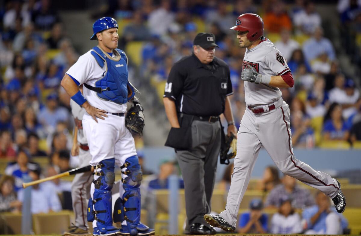 Diamondbacks catcher A.J. Pollock crosses home plate after hitting a solo homer during a game at Dodger Stadium on Sept. 22 . Dodgers catcher A.J. Ellis watches along with home plate umpire Hunter Wendelstedt.