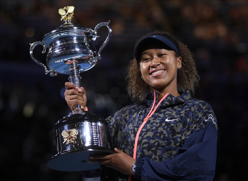 FILE - Japan's Naomi Osaka holds the Daphne Akhurst Memorial Cup aloft after defeating United States Jennifer Brady in the women's singles final at the Australian Open tennis championship in Melbourne, Australia, Saturday, Feb. 20, 2021. Naomi Osaka returns to the Australian Open as its defending champion and with what she says is a fresh outlook after last year’s roller-coaster. (AP Photo/Andy Brownbill, File)