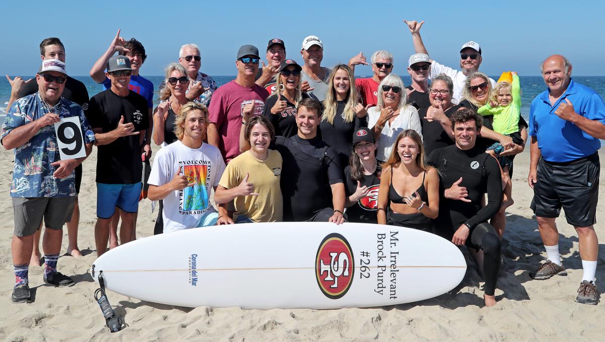 Mr. Irrelevant Brock Purdy, bottom center, poses with family and friends before taking surf lessons.