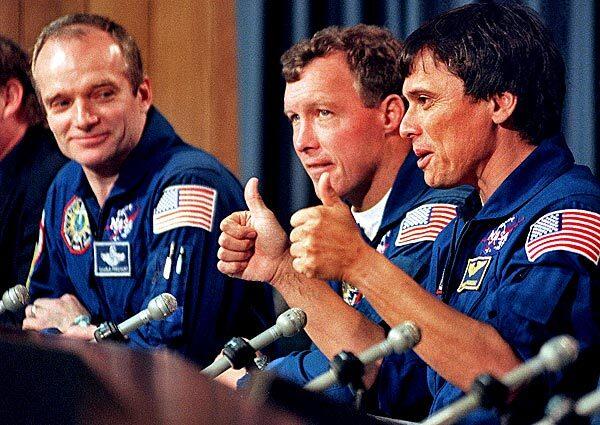 From left, American shuttle astronauts Charles Precourt and Dominic Gorie listen as Franklin Chang-Diaz speaks at a news conference at Florida's Kennedy Space Center after the return of Discovery. Chang-Diaz is discussing the health of fellow astronaut Andrew Thomas, who spent about 4 1/2 months aboard the Russian space station Mir and came back aboard Discovery.