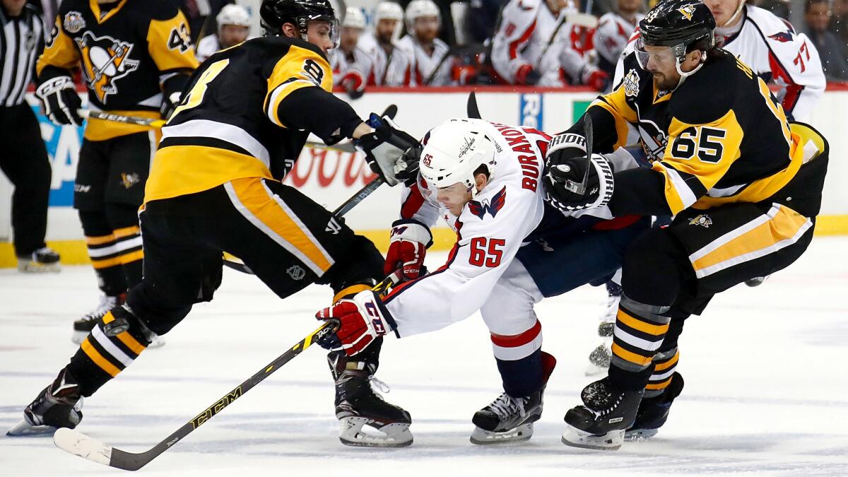 Capitals left wing Andre Burakovsky tries to split the defense of Pittsburgh's Brian Dumoulin (8) and Ron Hainsey (65) during Game 6 on Monday night.