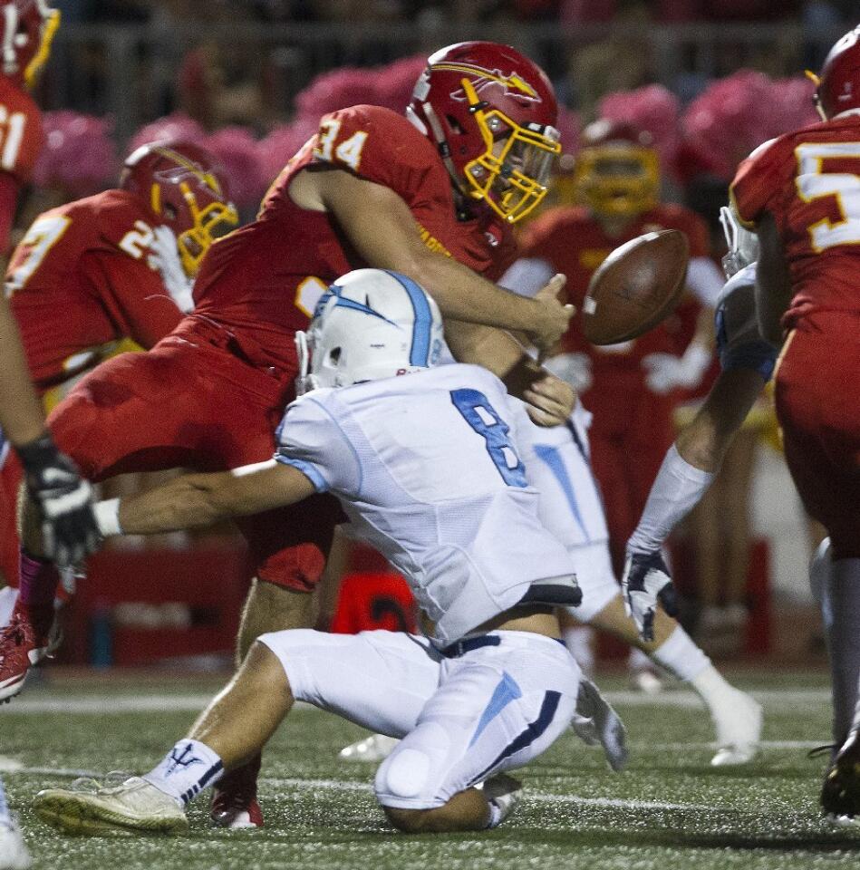 Corona del Mar High's Taylor Damron (8) causes Woodbridge's Connor McBride (34) to fumble.