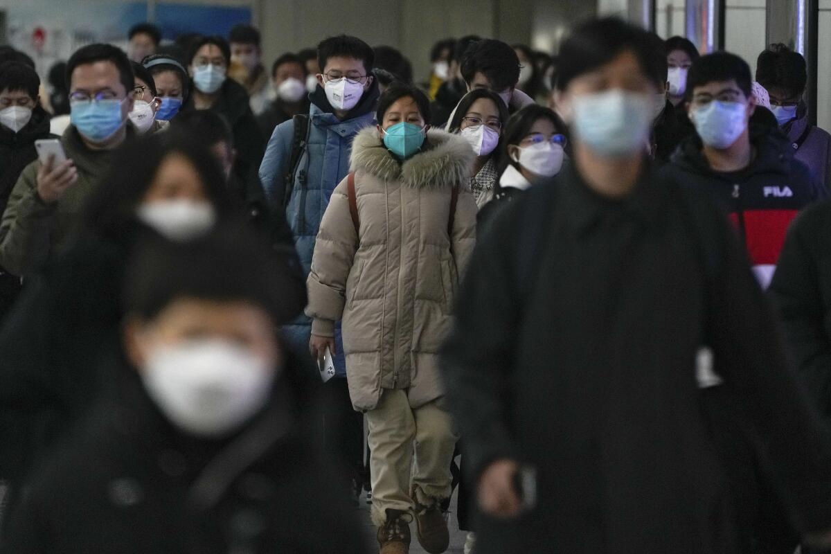 A crowd of commuters wearing face masks 