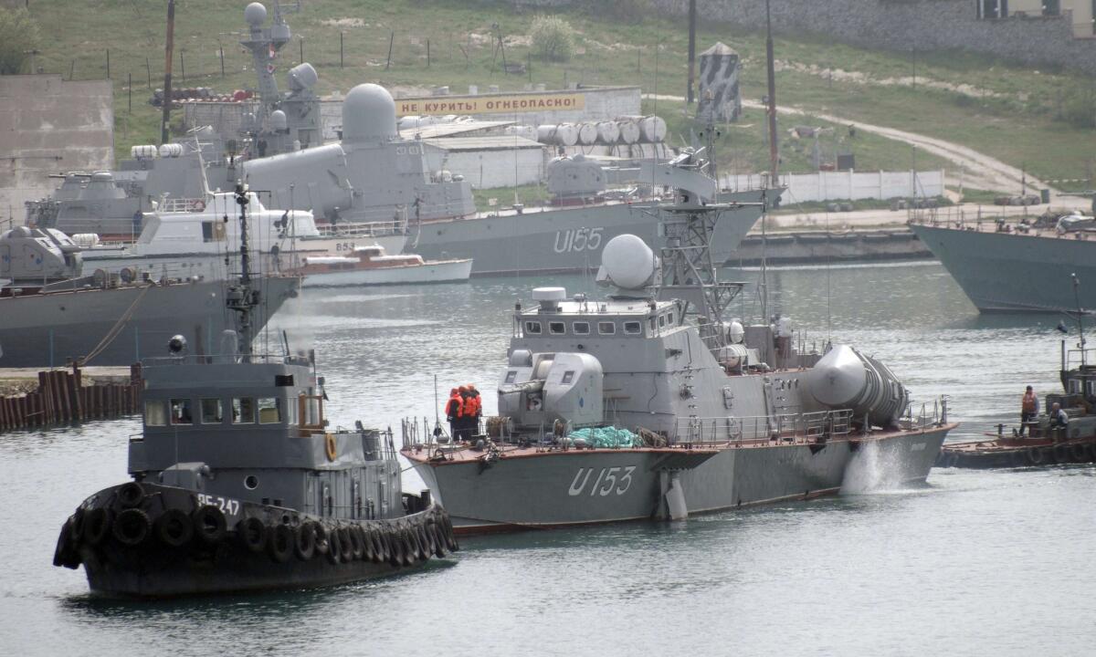 A Ukrainian guided-missile cruiser is towed from Sevastopol's bay to be transferred to the Ukrainian Defense Ministry's control after Russia's takeover of the Crimean peninsula.