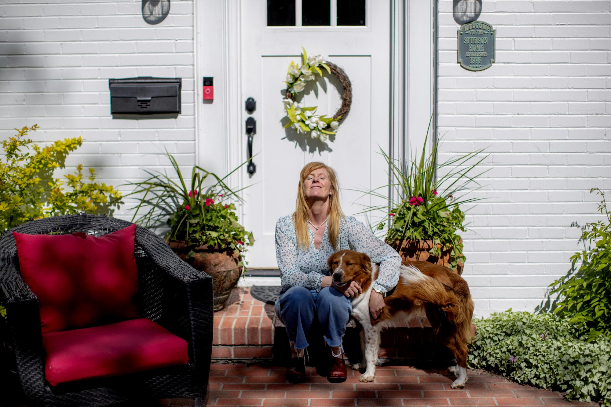 A woman with her dog on a porch