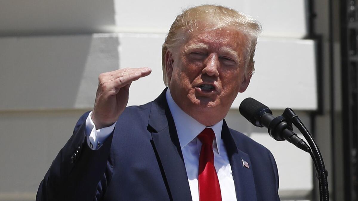 President Trump speaks to reporters on the South Lawn of the White House on Monday, defending his policies on immigration and other issues.