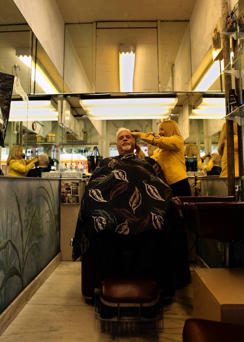 Jan Bruno cuts Carlos Gaivar's hair at her tiny one-chair shop at Hollywood Boulevard and Vine Street in Hollywood. Bruno has owned the shop for 23 years; the building's new owners have told her she must leave.