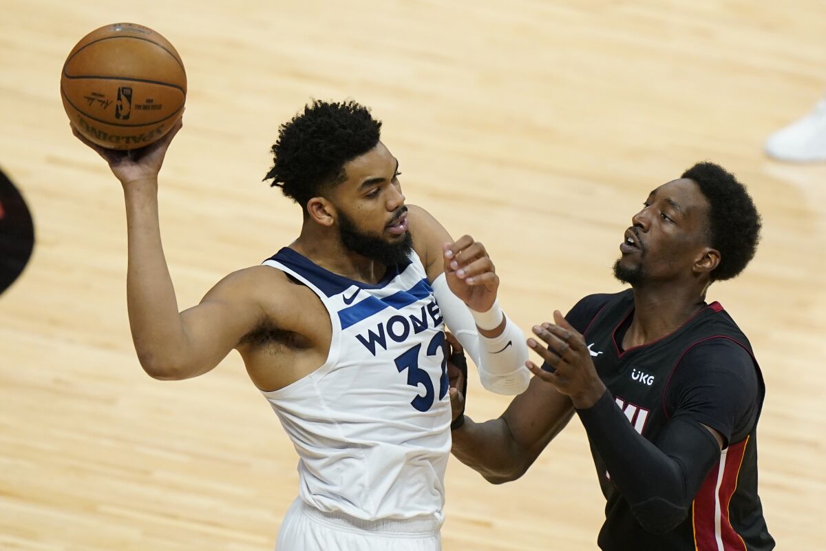 Minnesota Timberwolves center Karl-Anthony Towns (32) looks for an open teammate past Miami Heat center Bam Adebayo during the first half of an NBA basketball game, Friday, May 7, 2021, in Miami. (AP Photo/Wilfredo Lee)