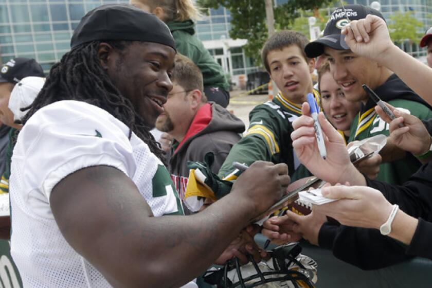Green Bay Packers' Eddie Lacy signs autographs before the start of training camp on Saturday.