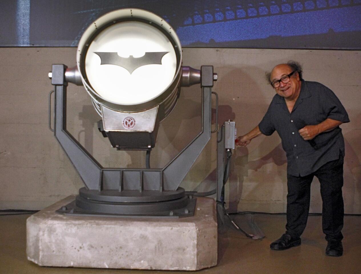 Actor Danny DeVito, who played Edward Cobblepot, better known as The Penguin, from the 1992 movie Batman Returns, throws the switch on the bat signal for the official opening of the Batman's 75th Anniversary Warner Bros VIP Studio Tour exhibit at the Warner Bros. studios in Burbank on Thursday, June 26, 2014.