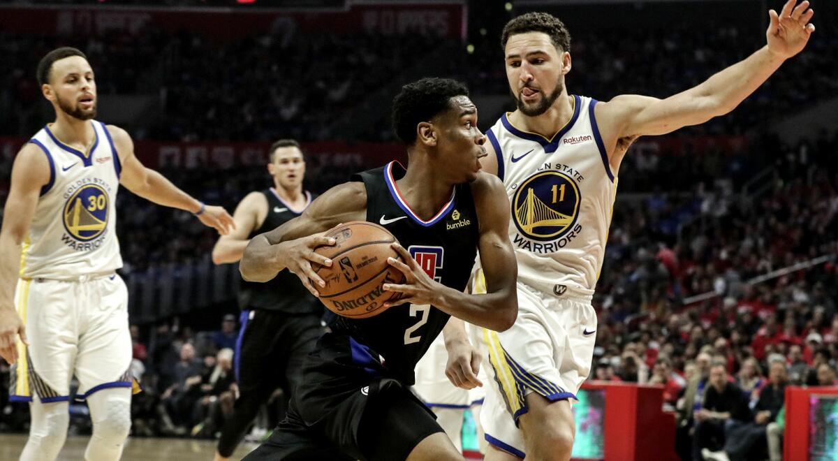 Clippers guard Shai Gilgeous-Alexander drives past Warriors guard Klay Thompson during the third quarter Sunday.