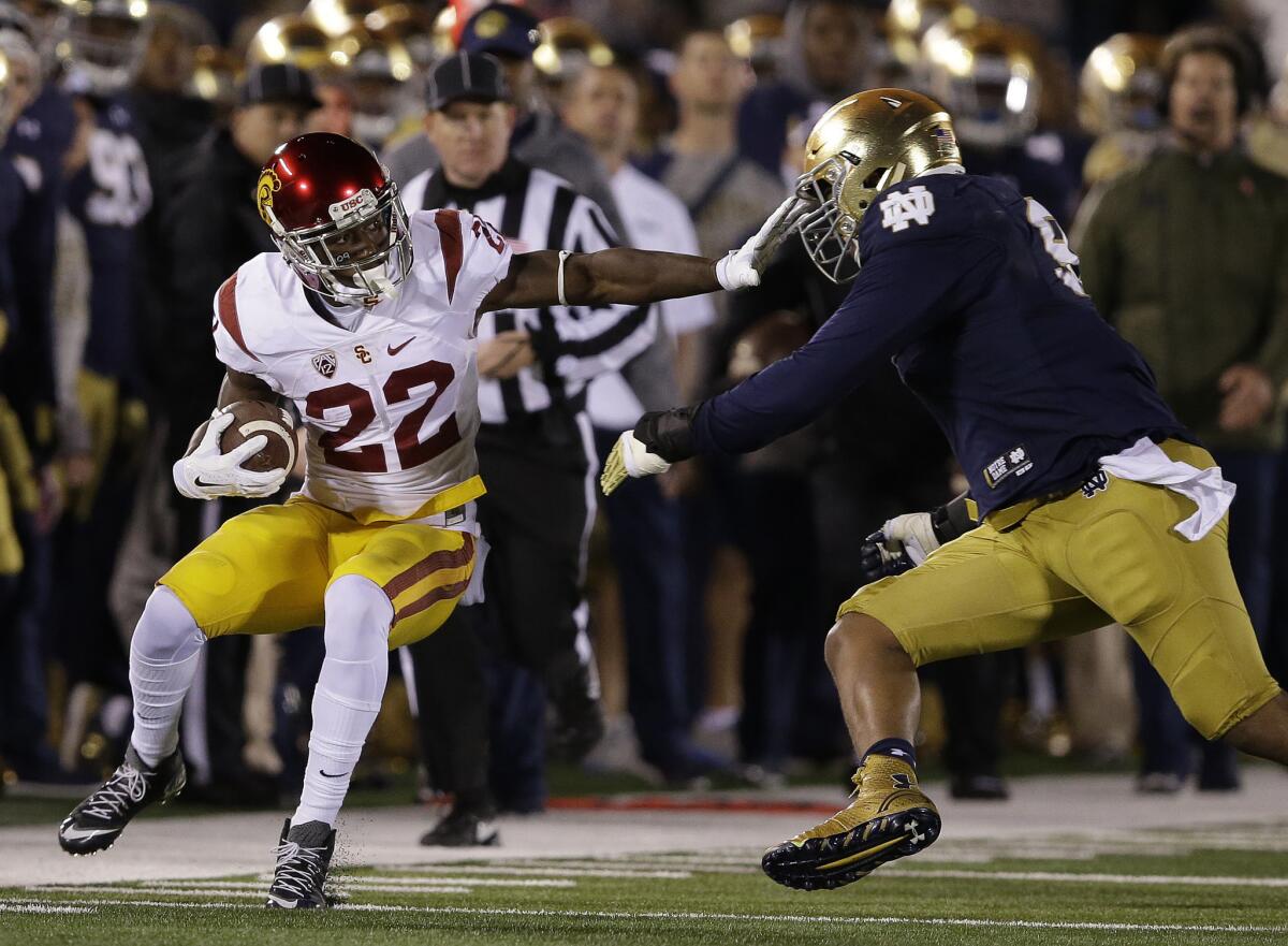 USC running back Justin Davis is tackled by Notre Dame linebacker Jaylon Smith during a game last fall.
