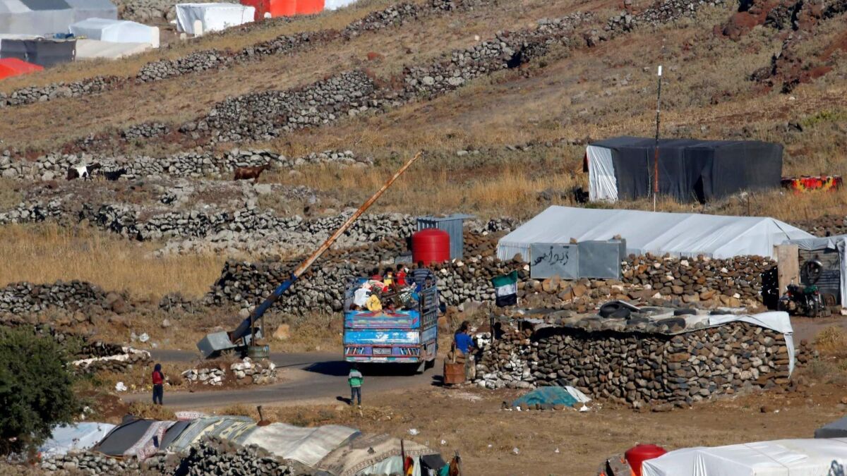 A truck carrying civilians arrives Saturday at a camp for displaced Syrians near the Syrian village of Burayqah in the southern province of Qunaiterah.