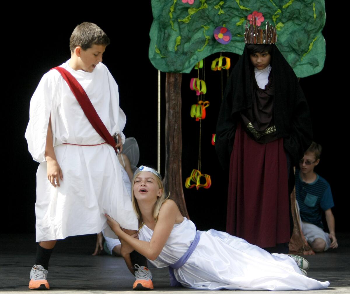 Addie Miller, playing Helena, grabs onto Demetrius, played by Michael Cutone, during rehearsal of the Burbank Youth Summer Theater's A Midsummer Night's Dream at the Starlight Bowl in Burbank on Tuesday, June 24, 2014.