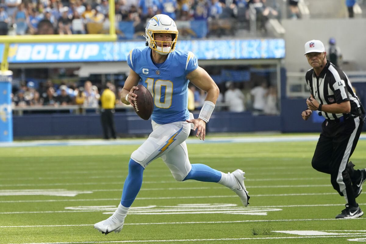 Los Angeles Chargers quarterback Justin Herbert (10) rolls out during the second half of an NFL football game against the Jacksonville Jaguars in Inglewood, Calif., Sunday, Sept. 25, 2022. (AP Photo/Marcio Jose Sanchez)