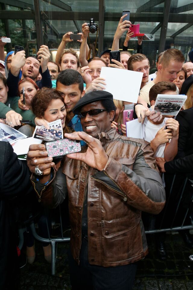 Wesley Snipes grabs a shot for fans as he attends the premiere of the film "The Expendables 3" at Residenz Kino in Cologne, Germany, on Aug. 3.