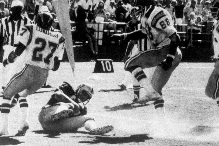 FILE - In this Sept. 11, 1978, file photo, Oakland Raiders' Dave Casper falls in the endzone for a touchdown against the San Diego Chargers on the final play of a football game, in San Diego. The stage was set in San Diego when the Raiders had the ball at the Chargers 14, trailing 20-14 with 10 seconds left. Ken Stabler dropped back to pass and was pressured by Chargers linebacker Woodrow Lowe. With nowhere to throw the ball, Stabler either fumbled or pushed the ball forward on purpose, depending on which side of the rivalry is telling the story. Teammate Pete Banaszak then knocked the ball further ahead from about the 13-yard line as it rolled toward the end zone. Tight end Dave Casper kicked the ball forward at the 5 and then fell on it in the end zone with no time remaining. (Thane McIntosh/The San Diego Union-Tribune via AP)