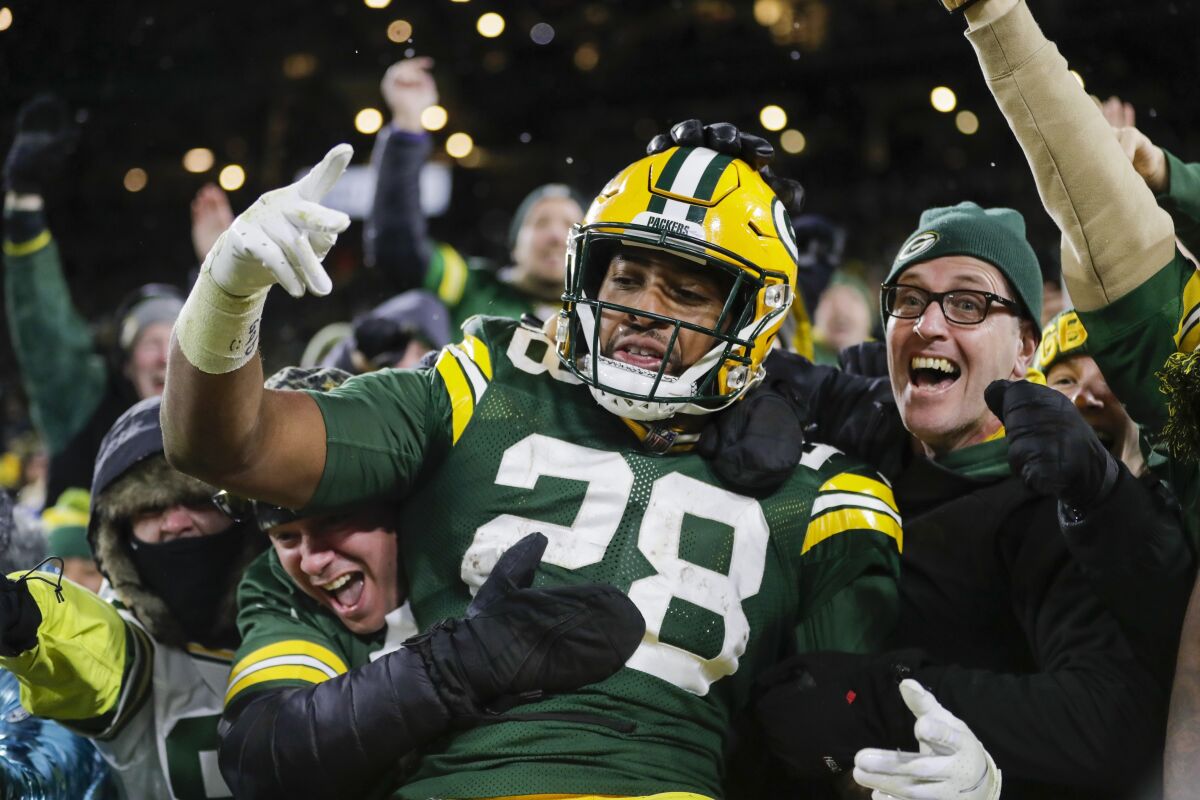 Green Bay Packers' AJ Dillon celebrates with fans after rushing for a touchdown during the second half of an NFL football game against the Seattle Seahawks Sunday, Nov. 14, 2021, in Green Bay, Wis. (AP Photo/Aaron Gash)