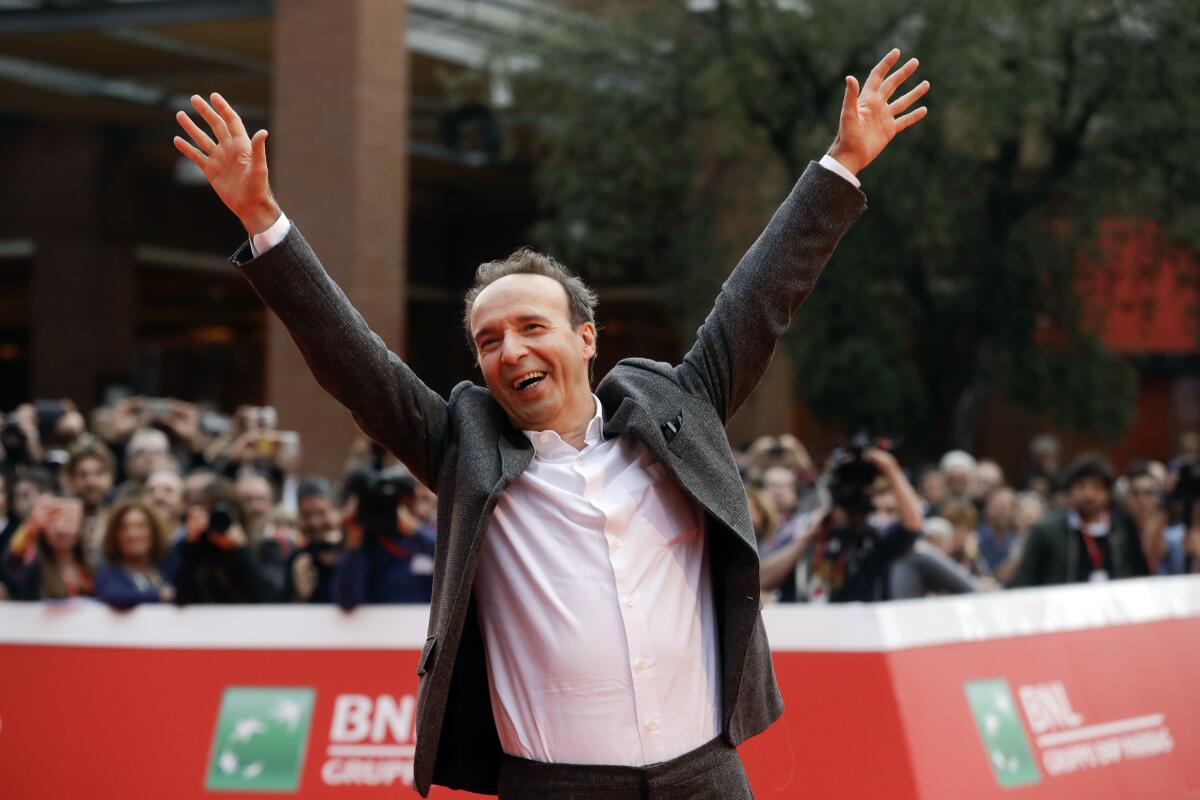 FILE - In this Sunday, Oct. 23, 2016 filer, Roberto Benigni poses for photographers as he arrives on the red carpet at the Rome Film Festival. The Venice Film Festival said Thursday, April 15, 2021 it will give its lifetime achievement award this year to Oscar-winning director and actor Roberto Benigni. The Golden Lion for Lifetime Achievement is to be awarded at 78th edition of the world’s oldest film festival, scheduled for Sept. 1-11 on the Lido. Benigni wrote, directed and starred in “La Vita e Bella,” (“Life is Beautiful”), which won the Oscar for best foreign language film, best actor and best musical score in 1999. (AP Photo/Gregorio Borgia, File)