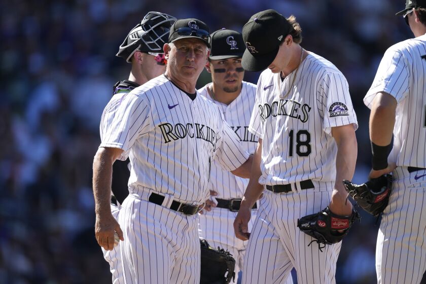 Colorado Rockies manager Bud Black, left, pulls starting pitcher Ryan Feltner (18) from the mound after he hit Milwaukee Brewers' Kolten Wong in the sixth inning of a baseball game Monday, Sept. 5, 2022, in Denver. (AP Photo/David Zalubowski)