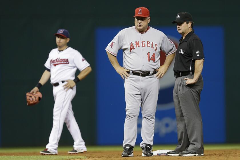 Angels Manager Mike Scioscia stands with second base umpire Rob Drake while deciding whether or not to challenge the ruling that Raul Ibanez was caught stealing by Cleveland in the eighth inning. Scioscia didn't challenege, the Angels lost 4-3.