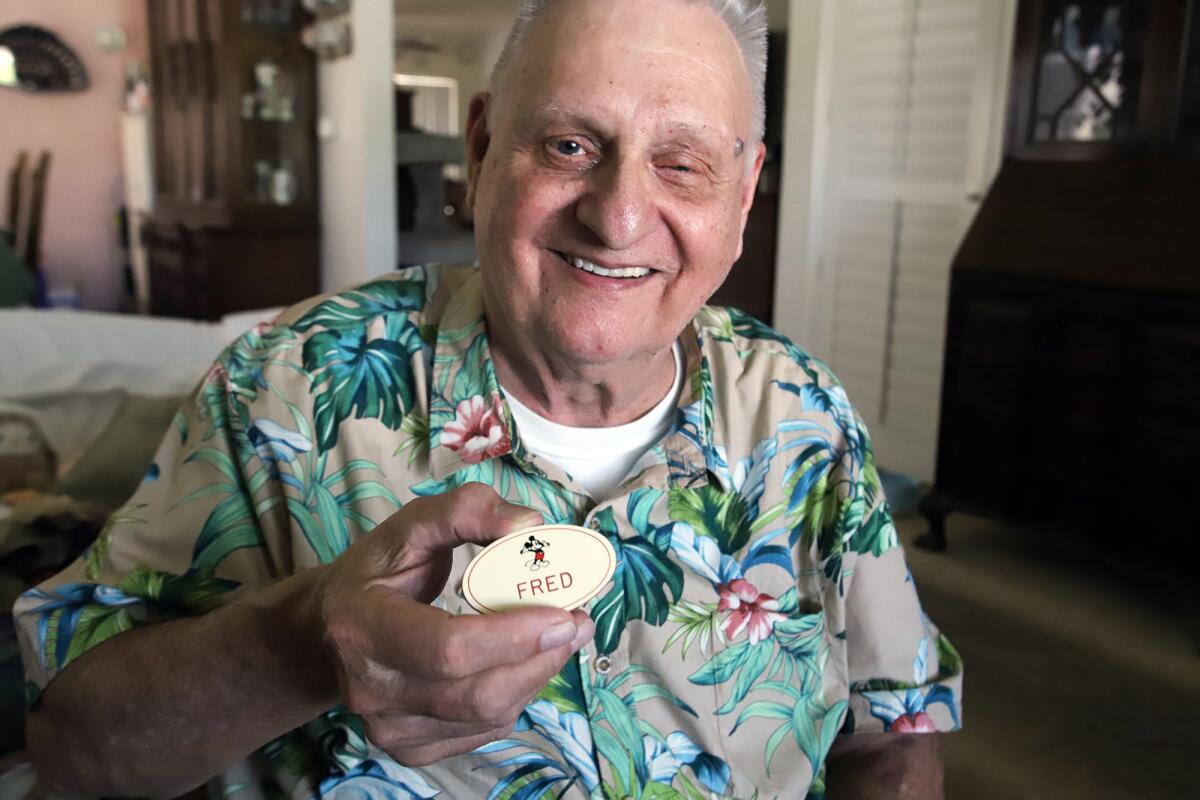Osterman holds the name badge that he used to wear during his time as a Disneyland sound mechanic.