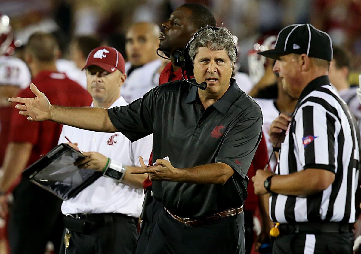 Washington State Coach Mike Leach talks with an official in the fourth quarter of a game against USC on Sept. 7, 2013.