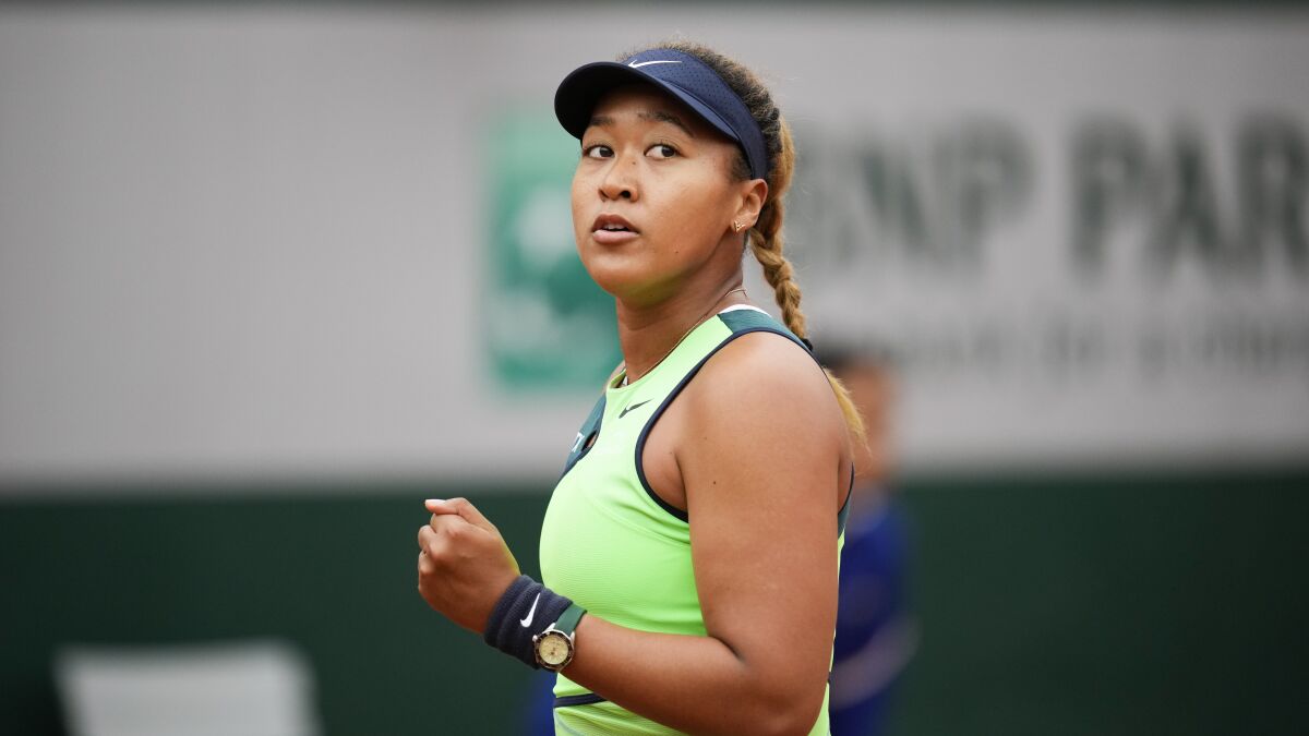 Naomi Osaka clenches her fist after scoring a point against Amanda Anisimova.
